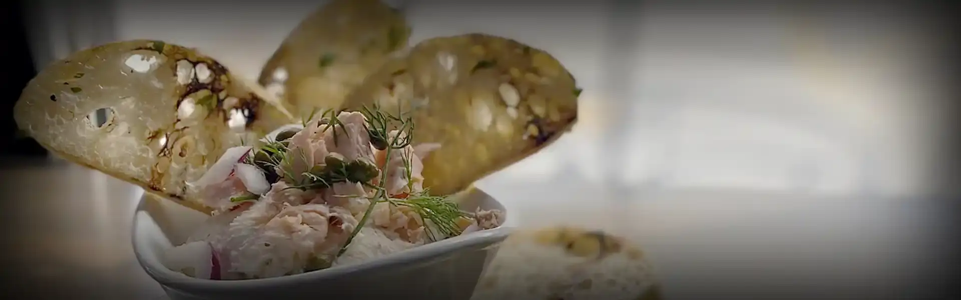 A bowl with dip and several slices of crostini